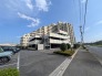 青空が広がる開放的なロケーションに佇む、落ち着いた佇まいの建物外観