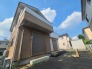 青空を背景に、落ち着いた佇まいが周囲の静かな住環境と調和する穏やかな街並みです。