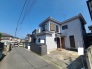 青く澄んだ空の下、周囲の街並みに穏やかに溶け込む落ち着いた佇まいの住まいです。