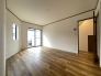 落ち着いた色調のフローリングが空間に広がりをもたらし、壁面の白さが全体を清潔感のある柔らかな雰囲気へと整えています。日々の暮らしに心地よい静けさと、穏やかな時の流れを感じさせてくれる佇まいです
