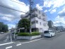 青空に映える落ち着いた色調の外観が、街並みに穏やかな表情を添えています。日常に安心感をもたらす、程よい距離感の佇まいが魅力です
