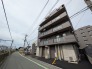 落ち着いた色合いの外観が街並みに馴染み、穏やかな日常を予感させる佇まい