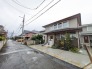落ち着いた色合いの外観と手入れされた植栽が穏やかな街並みに馴染む佇まい