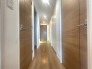 木目の美しい建具が整然と並び、奥行きを感じさせる落ち着いた佇まいの通路です
