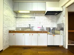 壁付のキッチンは上部に収納が作りやすいのがメリット。空間を有効活用したすっきりとしたデザイン。