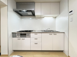 壁付のキッチンは上部に収納が作りやすいのがメリット。空間を有効活用したすっきりとしたデザイン。
