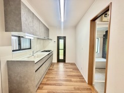 壁付のキッチンは上部に収納が作りやすいのがメリット。空間を有効活用したすっきりとしたデザイン。
