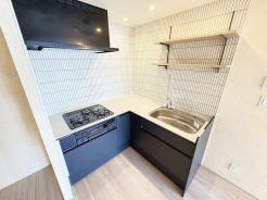 壁付のキッチンは上部に収納が作りやすいのがメリット。空間を有効活用したすっきりとしたデザイン。