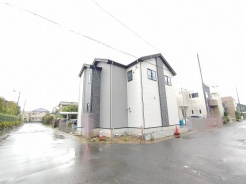 洗練されたツートーンの外壁が落ち着きをまとい、周辺の風景と自然に調和する端正な佇まいの住まいです。