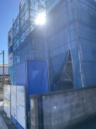 青いシートに包まれた、未来への期待が膨らむ建設現場