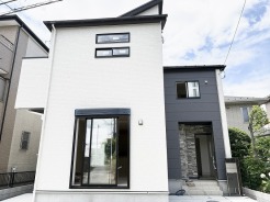 白とダークトーンのコントラストが洗練された印象を与え、街並みに美しく調和するモダンな外観です。