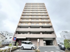 洗練されたフォルムが街並みに馴染む、落ち着いた佇まいのマンション外観です。
