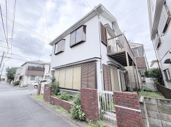 落ち着いた街並みに溶け込む、素朴で親しみやすい佇まいの住まい。