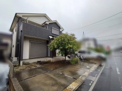 落ち着いた色合いの外観と豊かな緑が調和する、穏やかな佇まいが広がる住まいです。