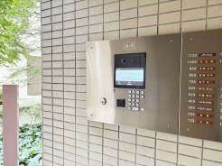 落ち着いた色合いのタイル壁に囲まれた、安心感を高めるスマートなエントランス仕様。