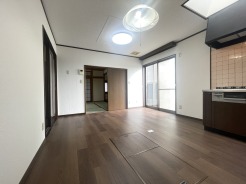 落ち着いた色調の床と白い壁が調和し、住まう人の個性を引き立てるシンプルな空間です。奥に広がる静かな趣きと、日々の暮らしに寄り添う心地よい開放感が、穏やかな時間を演出してくれます