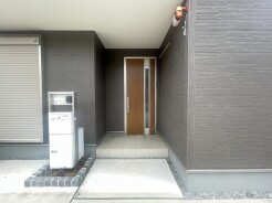 シックな色合いの外壁が洗練された印象を与え、木目の温もりが落ち着いた佇まいを演出する、日々の帰宅を心地よく迎えてくれる場所です