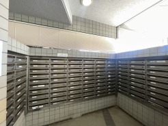 整然と並ぶ集合ポストが、住まいの規律と落ち着いた日常の始まりを感じさせてくれるエントランスです